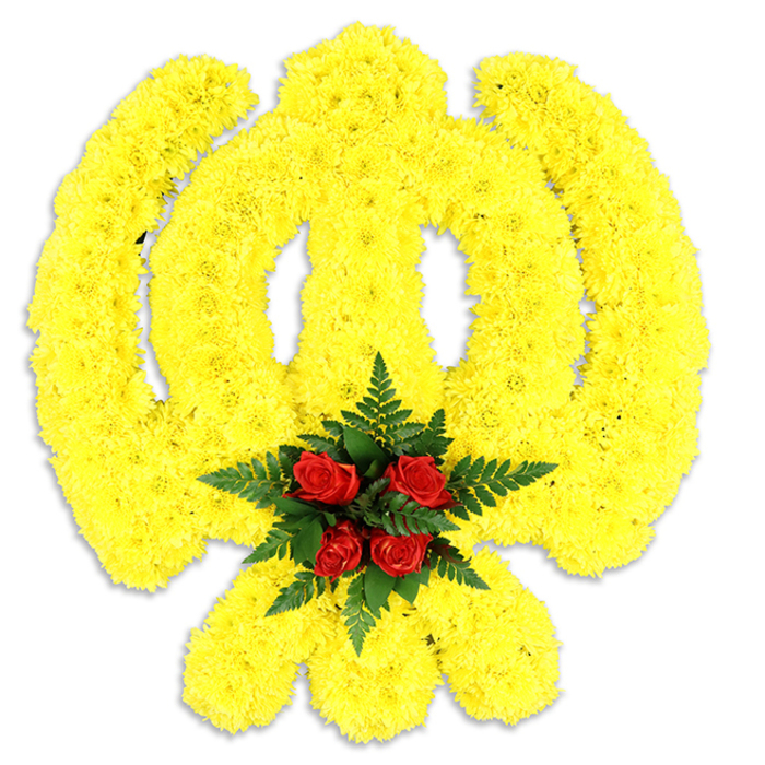 Framed against a pristine white backdrop, this large floral Khanda is an elegant and respectful translation of a sacred Sikh emblem into flowers: the circular chakkar, central double-edged sword and twin crossed kirpans are all precisely modelled from a dense layering of small, bright yellow chrysanthemum blooms. The chrysanthemums' tight placement builds gentle relief and a soft, tactile surface that seems to glow under soft photographic light, giving the emblem warmth and presence without diminishing its formal geometry. Nestled at the heart is a compact bouquet of five deep red roses, each bud arranged to create a low, luminous cluster, and they are cradled by rich, dark green fern fronds that provide both texture and a complementary cool tone. A subtle grey shadow beneath the composition confirms it as a physical tribute-suitable as a freestanding wreath or a central floral piece at a gurdwara, memorial service, or cultural celebration of Sikh heritage. The overall mood is one of solemn respect and quiet hope: yellow suggests remembrance and light, red conveys deep regard, and the fern's green introduces a note of calm. The scent is soft and garden-like-powdered chrysanthemum with the rounded warmth of rose-inviting a measured pause. As a local Palmers Green florist who often delivers to Broomfield Park events and nearby community gatherings, I imagine this piece placed with care to honour life, ritual and collective memory.