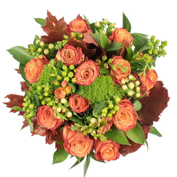 From a top-down perspective on a stark white backdrop, this circular autumn bouquet reads like a small landscape of fall: abundant roses, fully unfurled, progress in hue from warm peach to glowing orange and then to outer petals brushed with a reddish-rust, echoing the late-season tones of Palmers Green's tree-lined streets. Nestled among those roses are clusters of Hypericum berries-some bright lime, some a delicate creamy yellow-whose glossy spheres catch the light and create tiny, cheerful focal points. Adding an unexpected, velvety texture are the Green Trick dianthus mounds, their rich chartreuse green resembling moss or miniature shrubs and giving the arrangement an organic, tactile centre. Deeply coloured, lobed leaves in shades of burgundy and burnt red are woven through the design to strengthen the autumn theme and to introduce a shadowed, grounding contrast. Broader, shiny green leaves form a supportive backdrop, their smooth surfaces offsetting the roses' soft, layered petals and the dianthus' fuzzy density.

The composition is densely packed yet breathable; soft, diffuse lighting reveals the roses' velvety surfaces, the berries' polished skins, and the dianthus' fine texture while creating gentle gradations of shadow and depth. There is a quiet fragrance suggested by this mix-earthy greens beneath the classic sweetness of roses-that suits intimate gatherings or seasonal décor. Perfect for a Thanksgiving table or a thoughtful gift to a neighbour on Fox Lane or around Broomfield Park, this bouquet balances elegance and rustic charm with the warmth of harvest-time colours and the practiced hand of an experienced florist.