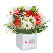 A surge of joyful energy radiates from this lush bouquet-expertly assembled by a Palmers Green florist well-versed in the soft celebration of everyday beauty. Plush coral and fervent red carnations seem to glow with warmth, their petals ruffled and inviting to the touch, their gentle fragrance promising comfort and cheer. White daisies, their golden-lime centers twinkling, offer pockets of happiness reminiscent of sunlit days in nearby parks. Wispy sprays of baby's breath flutter throughout the bouquet, infusing it with airy innocence and gentle lightness. A careful selection of unopened buds, tinted with a flush of purple on their tips, lends the arrangement intrigue and future promise. Flowing around the blooms, the deep green, glossy foliage forms an elegant embrace-a living frame that cradles the riot of colour within. The crisp white gift bag, with its sturdy handles, holds the ensemble upright, bathed in soft, natural light against a pure white backdrop, allowing each flower's character to shine. Ideal for birthdays, heartfelt congratulations, or simply to lift someone's spirits across Palmers Green, this bouquet is a reflection of mindful floristry-each detail a testament to attentive, local care.